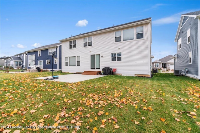 rear view of property featuring a lawn, a patio area, and central AC