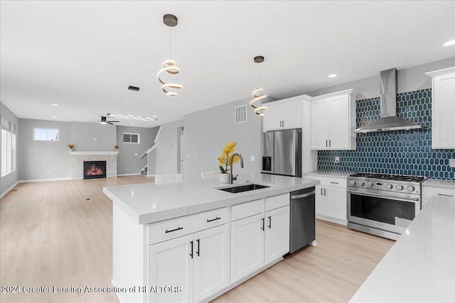 kitchen featuring white cabinets, sink, wall chimney exhaust hood, and appliances with stainless steel finishes