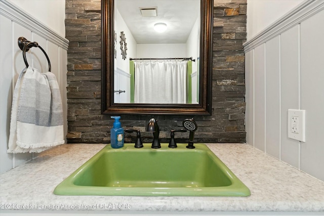 bathroom featuring tasteful backsplash, a shower with curtain, and sink