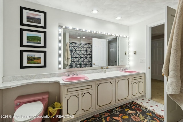 bathroom with tile patterned flooring, vanity, and toilet