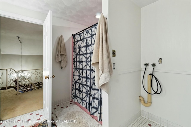 bathroom featuring tile patterned flooring and a notable chandelier