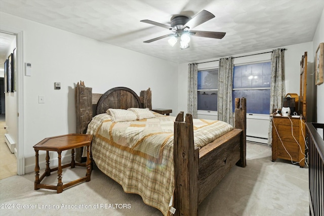 carpeted bedroom with ceiling fan and a baseboard radiator