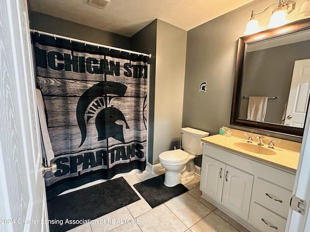 bathroom featuring tile patterned flooring, vanity, and toilet