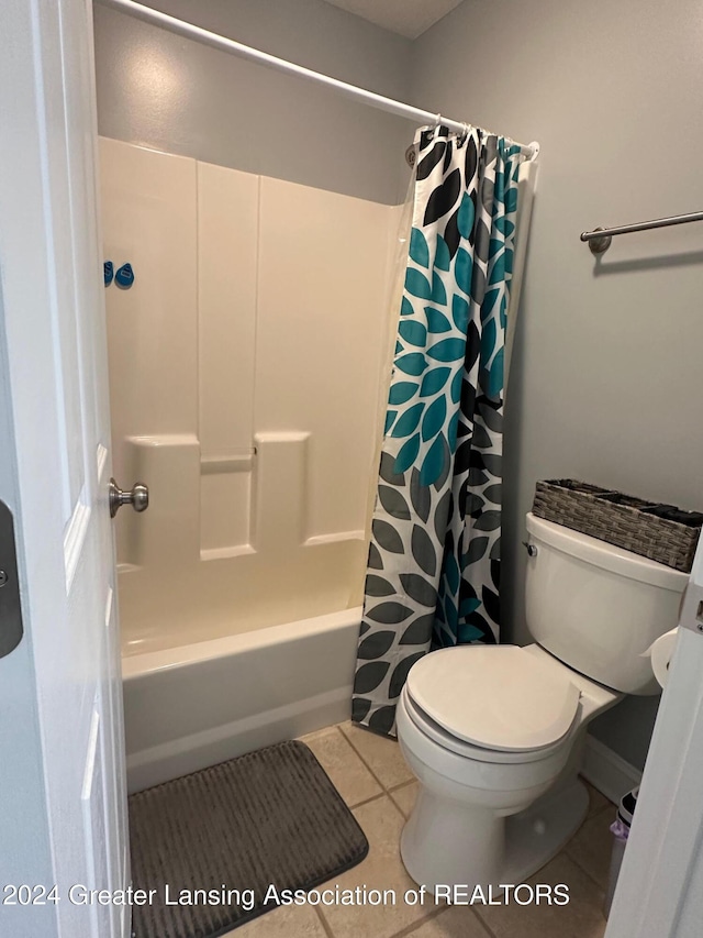 bathroom with tile patterned floors, shower / bath combination with curtain, and toilet