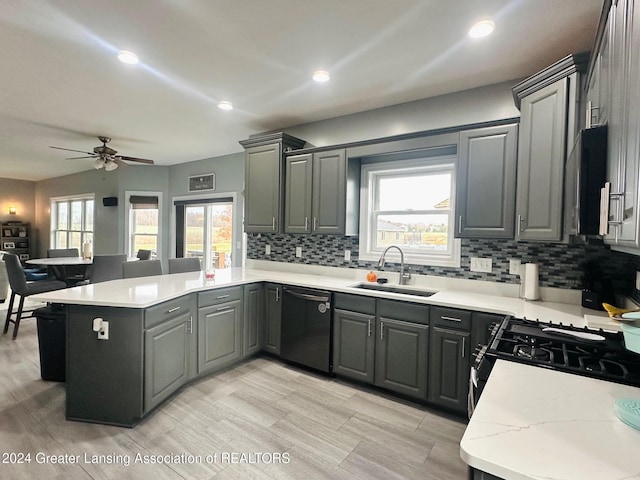 kitchen with gray cabinetry, black dishwasher, sink, and a wealth of natural light