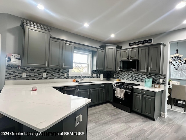 kitchen with kitchen peninsula, sink, gray cabinets, and black gas range oven