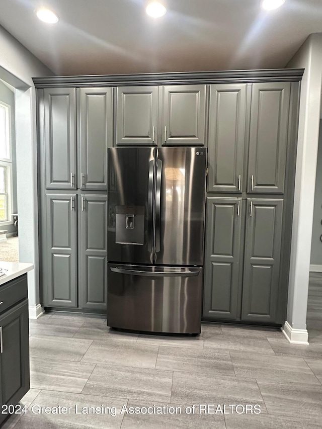 kitchen with stainless steel fridge with ice dispenser, light hardwood / wood-style flooring, and gray cabinetry