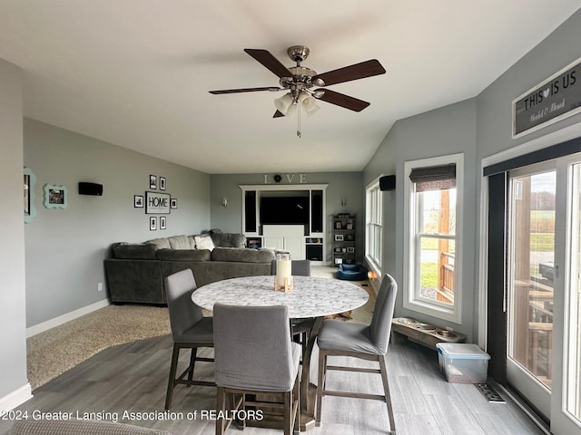 dining area featuring ceiling fan, wood-type flooring, and vaulted ceiling