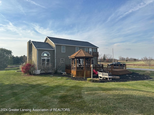 back of property with a lawn and a wooden deck