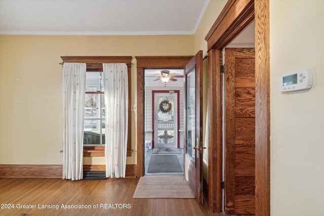 entrance foyer with ceiling fan, hardwood / wood-style floors, and ornamental molding