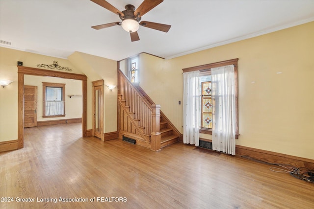 foyer entrance featuring a wealth of natural light, ceiling fan, ornamental molding, and hardwood / wood-style flooring