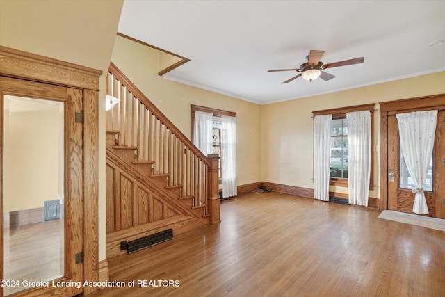 interior space with hardwood / wood-style flooring, ceiling fan, and ornamental molding