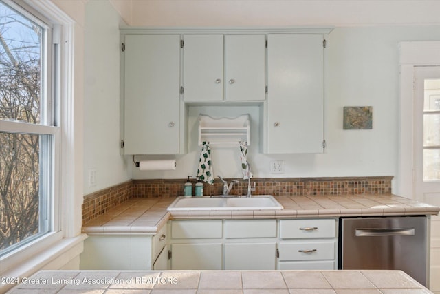 kitchen with dishwasher, tile countertops, white cabinetry, and sink