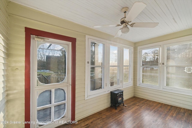 sunroom featuring a wood stove, ceiling fan, and wooden ceiling