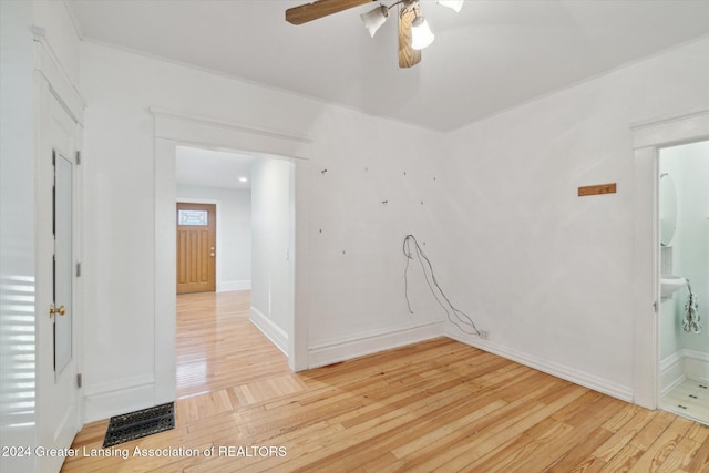 empty room with ceiling fan and light hardwood / wood-style flooring