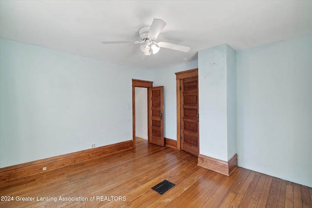 empty room with hardwood / wood-style flooring and ceiling fan