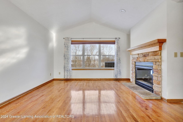 unfurnished living room with a fireplace, hardwood / wood-style flooring, and lofted ceiling