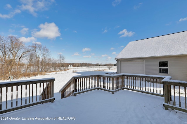 snow covered deck featuring a garage