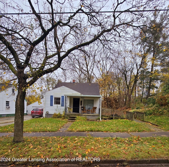 bungalow-style house featuring covered porch and a front lawn