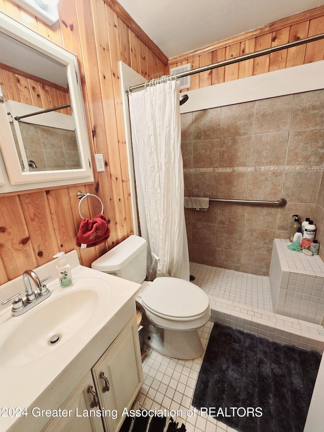 bathroom featuring tile patterned flooring, vanity, wood walls, and toilet