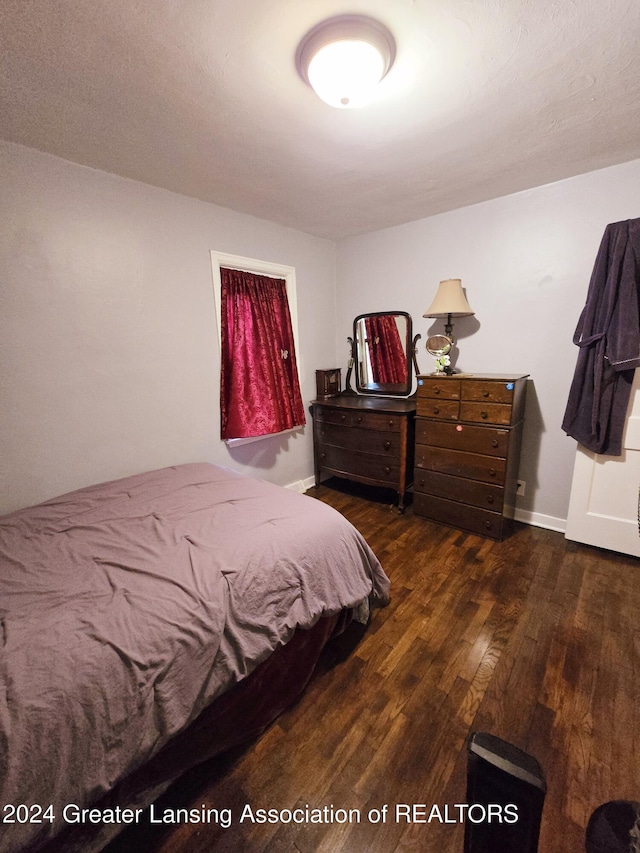 bedroom with dark wood-type flooring