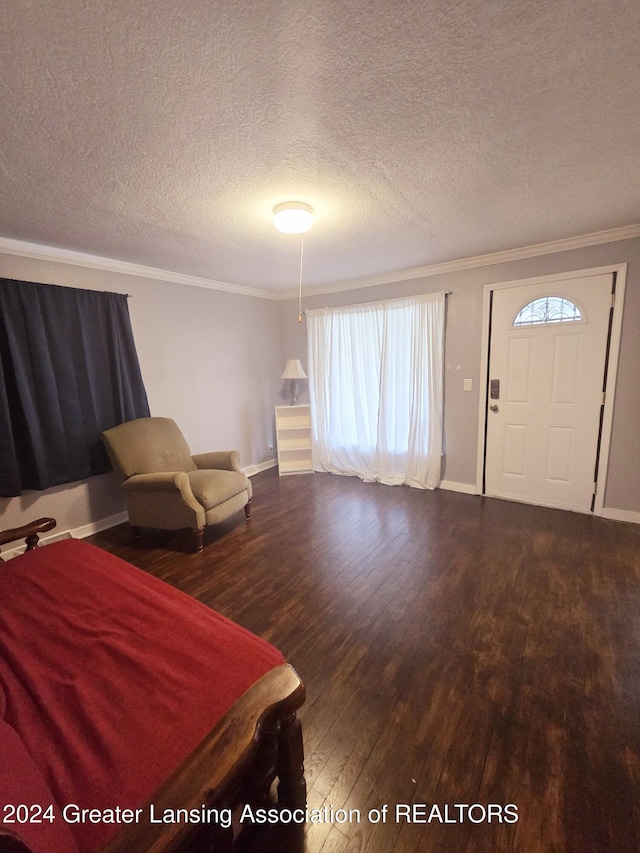 foyer entrance with hardwood / wood-style floors, a textured ceiling, and ornamental molding