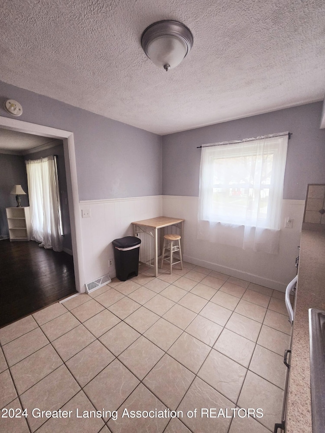 tiled empty room with a textured ceiling