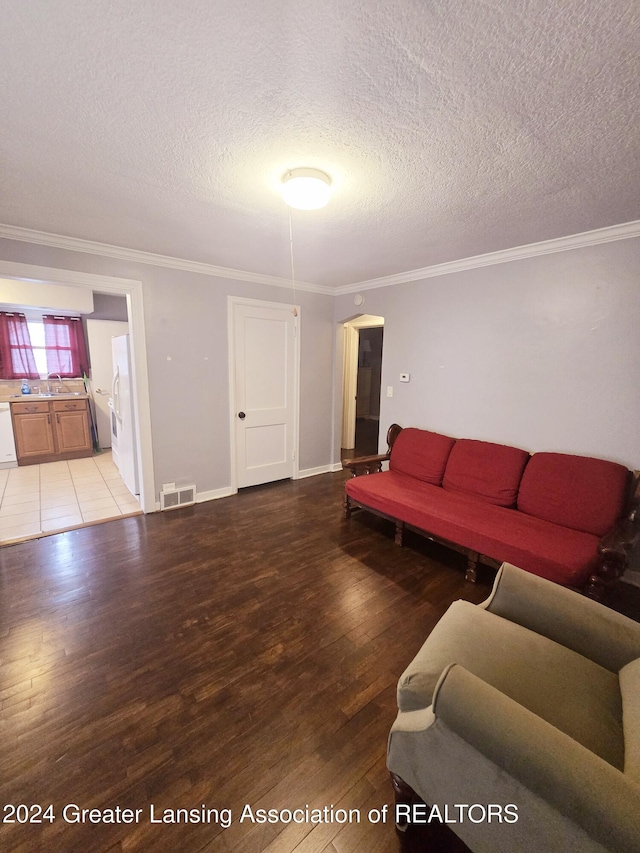 living room with wood-type flooring, a textured ceiling, and ornamental molding