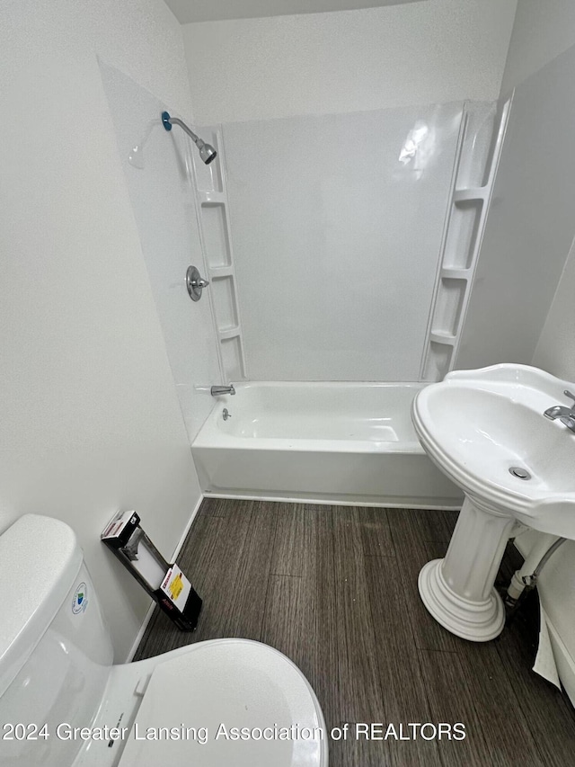 bathroom with shower / tub combination, toilet, and wood-type flooring