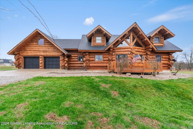 log-style house with a garage, a front lawn, and a deck