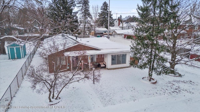 snow covered house with a storage shed