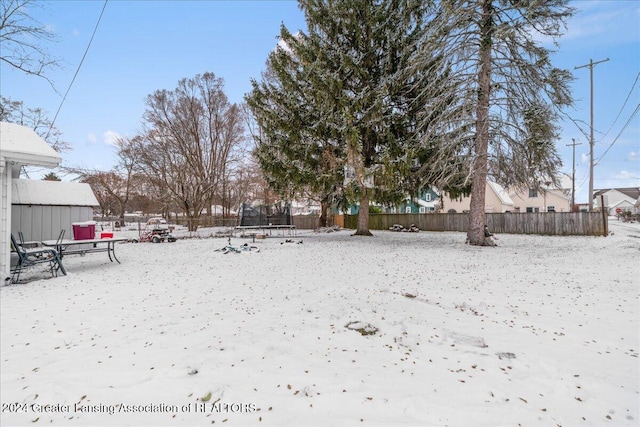 yard covered in snow with a trampoline