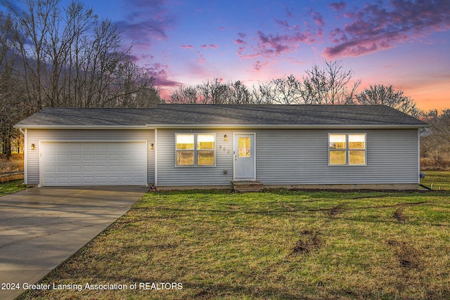 single story home with a yard and a garage