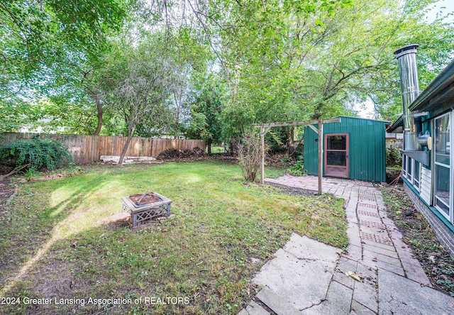 view of yard featuring a storage shed and an outdoor fire pit