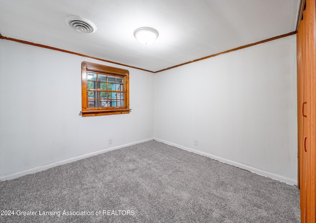 empty room with carpet flooring and crown molding