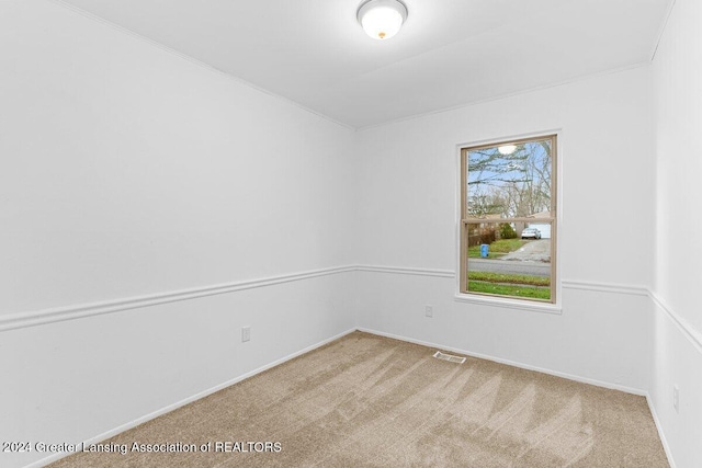 carpeted empty room featuring ornamental molding