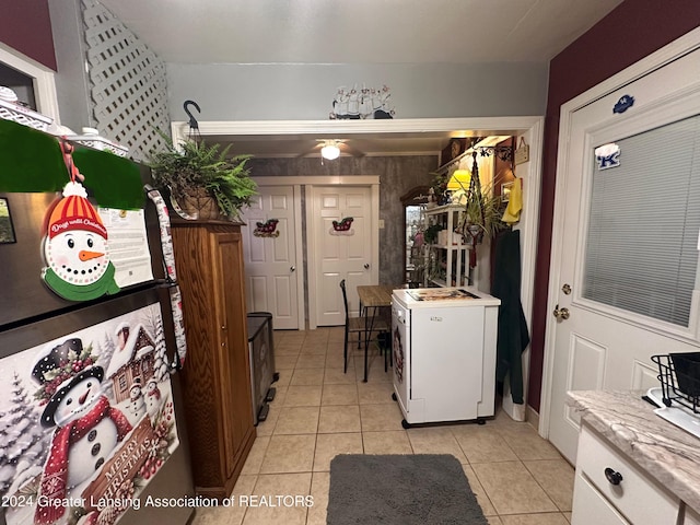 kitchen with fridge, white cabinets, white fridge, and light tile patterned floors