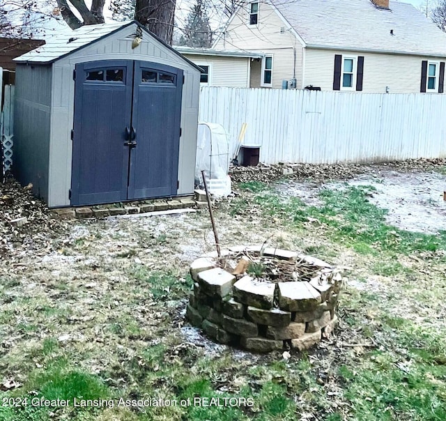 view of yard featuring a fire pit and a storage shed