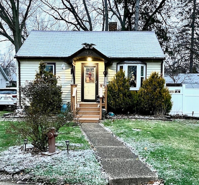 bungalow-style home featuring a front lawn