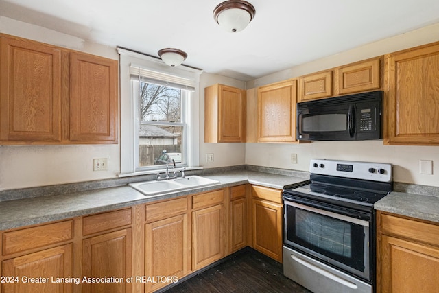 kitchen with dark wood-type flooring, stainless steel range with electric cooktop, and sink