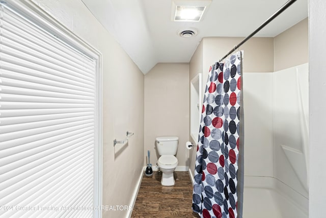 bathroom featuring vaulted ceiling, hardwood / wood-style flooring, toilet, and walk in shower