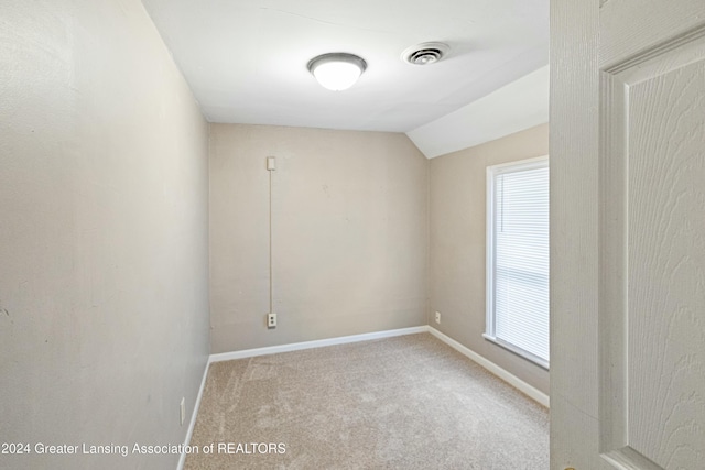 carpeted empty room featuring vaulted ceiling and a healthy amount of sunlight