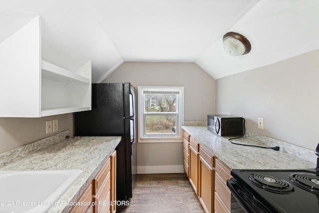 kitchen featuring light stone countertops, black appliances, vaulted ceiling, and wood-type flooring