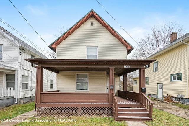 rear view of property featuring covered porch