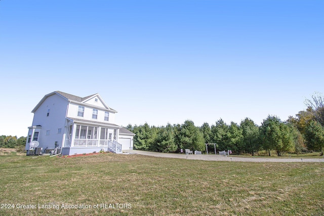 exterior space with a front yard, a garage, and a sunroom