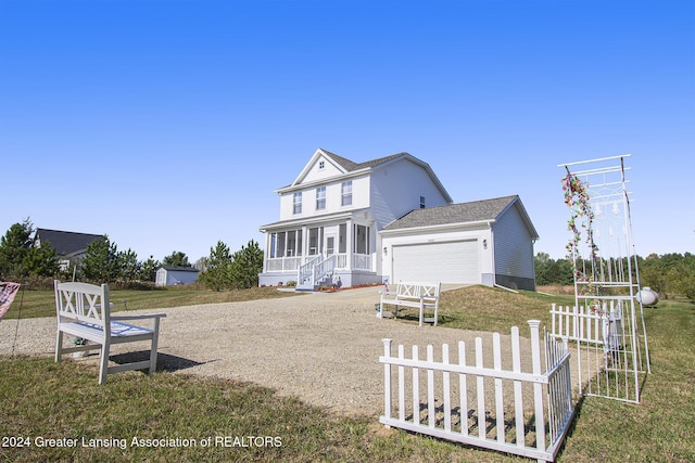 view of front of house featuring a sunroom, a front lawn, and a garage