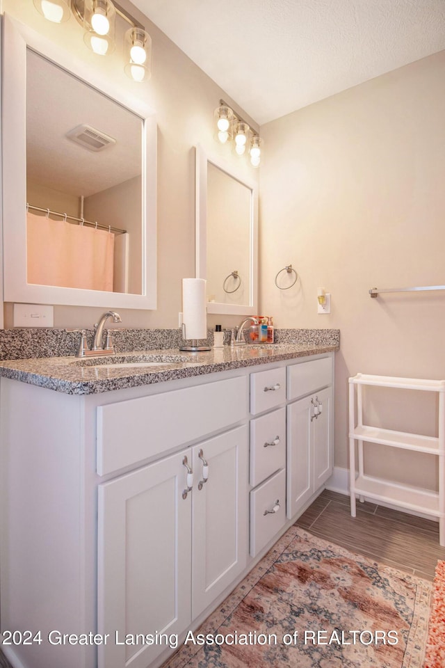 bathroom with vanity, a textured ceiling, and hardwood / wood-style flooring