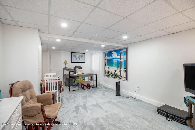 sitting room with a paneled ceiling and light colored carpet