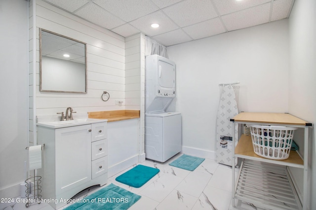 bathroom featuring a drop ceiling, vanity, and stacked washer and clothes dryer