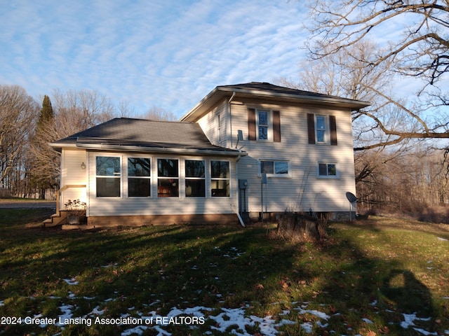 rear view of property featuring a yard